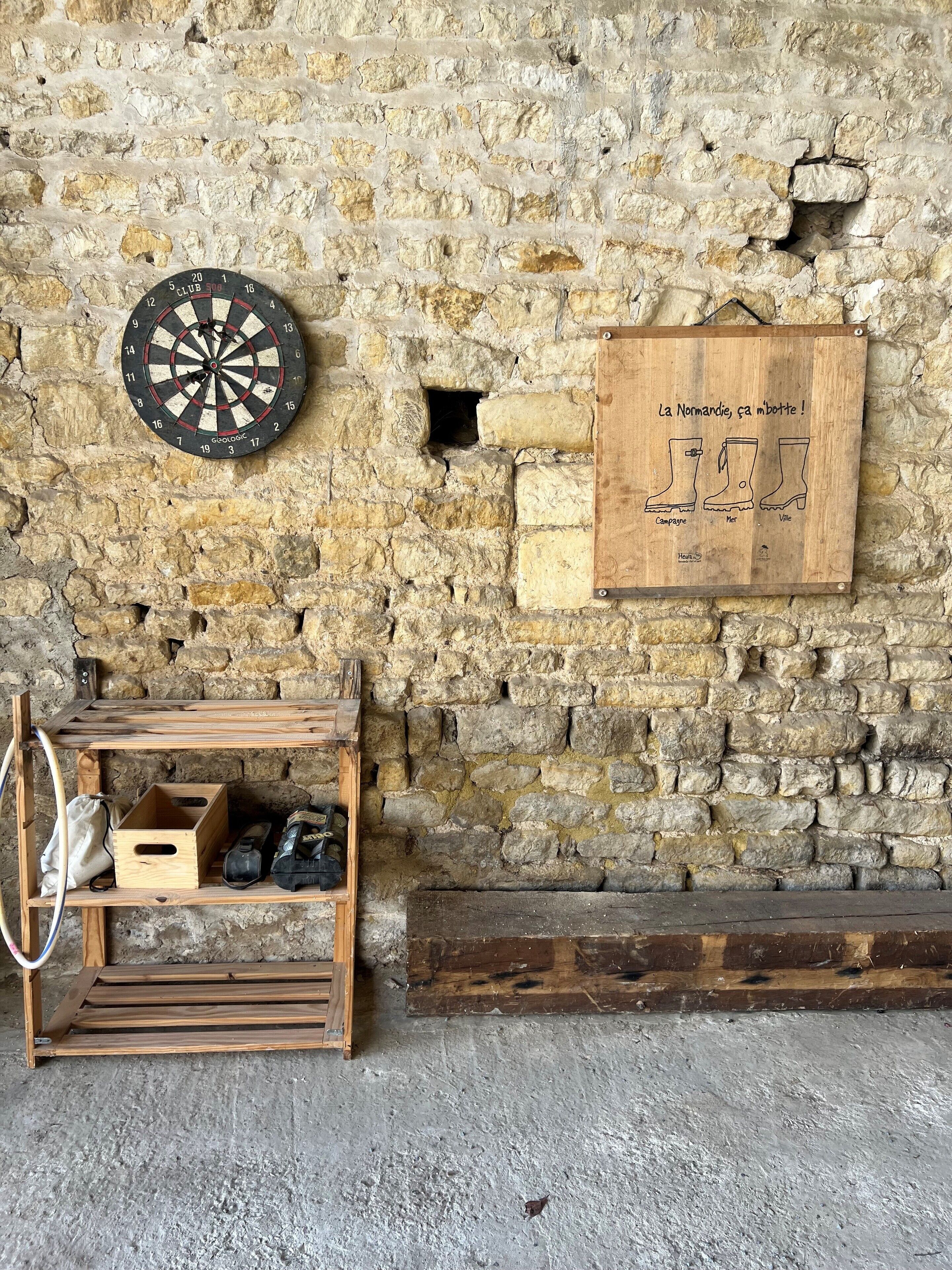 Een rustieke stenen muur met een dartbord en een houten bord.