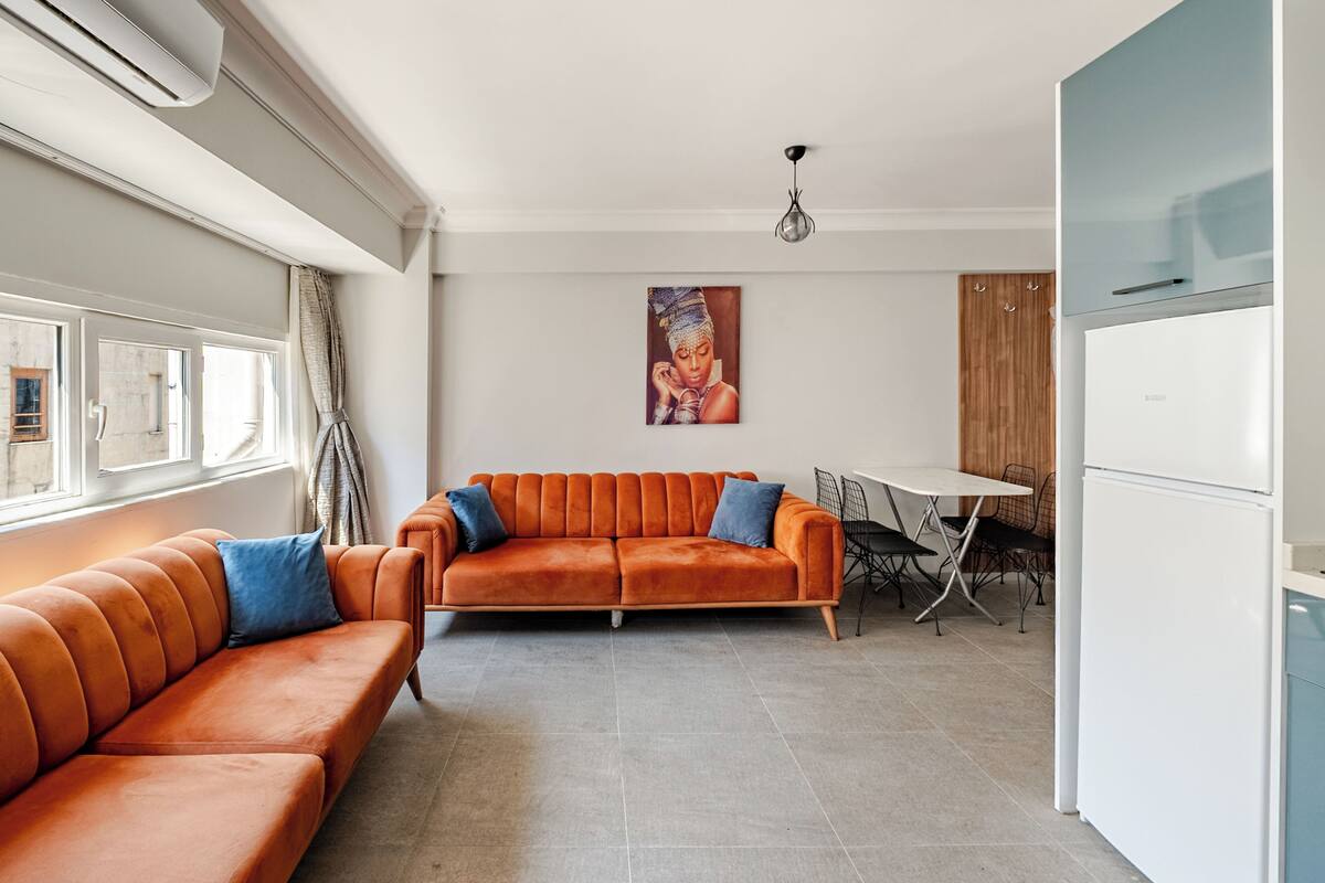 Una sala de estar moderna con un sofá, una mesa de comedor y una zona de cocina.