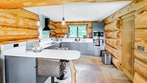 Une cuisine moderne avec un îlot central, des tabourets de bar et des murs recouverts de panneaux de bois.