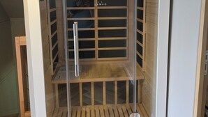 Une pièce moderne et fermée, dotée d’une porte en verre, d’étagères en bois et d’une poignée en métal.