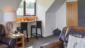 A cozy room with a dining area, a sofa, and a window with a view. - 1 bedroom accommodation in Dippen, near Whiting Bay, Isle of Arran (Dippen, near Whiting Bay, Isle of Arran)