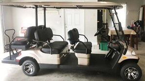 A golf cart with two seats and a steering wheel, parked indoors. - Blast at the Beach - Golf Cart Available to Rent! Pet Friendly! (Destin)
