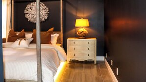 Ein Schlafzimmer mit einem Himmelbett, einer Nachttischlampe und einem Wanddekor.