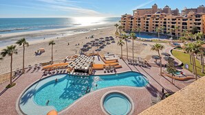 Un resort con una piscina ampia, accesso diretto alla spiaggia e vista sull'oceano.