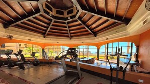 Una palestra con tapis roulant, ellittiche e un vogatore. Grandi finestre offrono vista sull'esterno.
