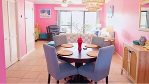 A dining area with a round table, chairs, and a chandelier. - Pink Dream House in PCB - Beach, Pools, Hot Tub, Clubhouse, Dog-Friendly (Panama City)