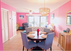 A dining area with a round table, chairs, and a chandelier. - Pink Dream House in PCB - Beach, Pools, Hot Tub, Clubhouse, Dog-Friendly (Panama City)