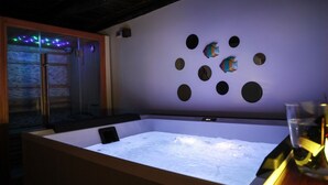 Una habitación con una tina de inmersión de hielo grande, techo de madera y pared con orificios circulares.