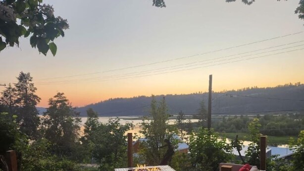 An outdoor seating area with sofas and a fire pit, overlooking a lake and hills. - House in Harrison with Lake View (Harrison)