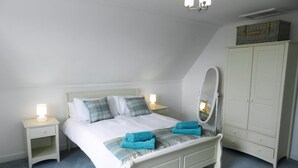 A bedroom with a bed, nightstands, a wardrobe, and a mirror. - 3 bedroom accommodation in Corrie, Isle of Arran (Corrie, Isle of Arran)