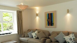 A living room with a sofa set, a coffee table, and a painting on the wall. - 2 bedroom accommodation in Corrie, Isle of Arran (Corrie, Isle of Arran)