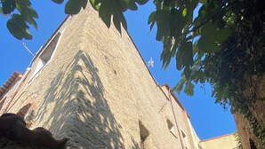 A rustic stone building with a narrow passageway and an archway leading to a scenic view. - Historic house surrounded by greenery, near outdoor activities and sea (Liguria)