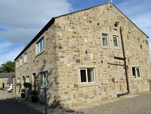 A stone building with multiple windows, a visible door, and a clear sky. - Ideally placed between the quaint market towns of Skipton and Settle. (Paythorne, near Skipton)
