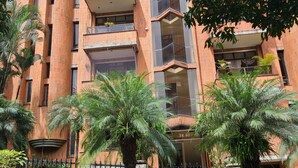 Un immeuble à plusieurs étages, doté d’une façade en briques, de balcons et d’une entrée fermée par un portail.