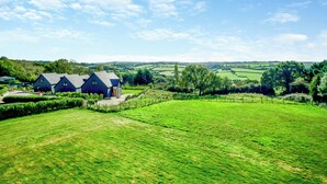 Paisaje rural con una casa y extensos campos verdes.