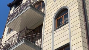 Un bâtiment d’hôtel doté d’un balcon et d’une enseigne indiquant « MENU DE L’HÔTEL ».