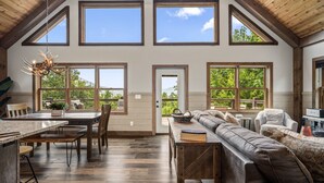 A spacious living area with a large wooden dining table, a sofa, and a fireplace.