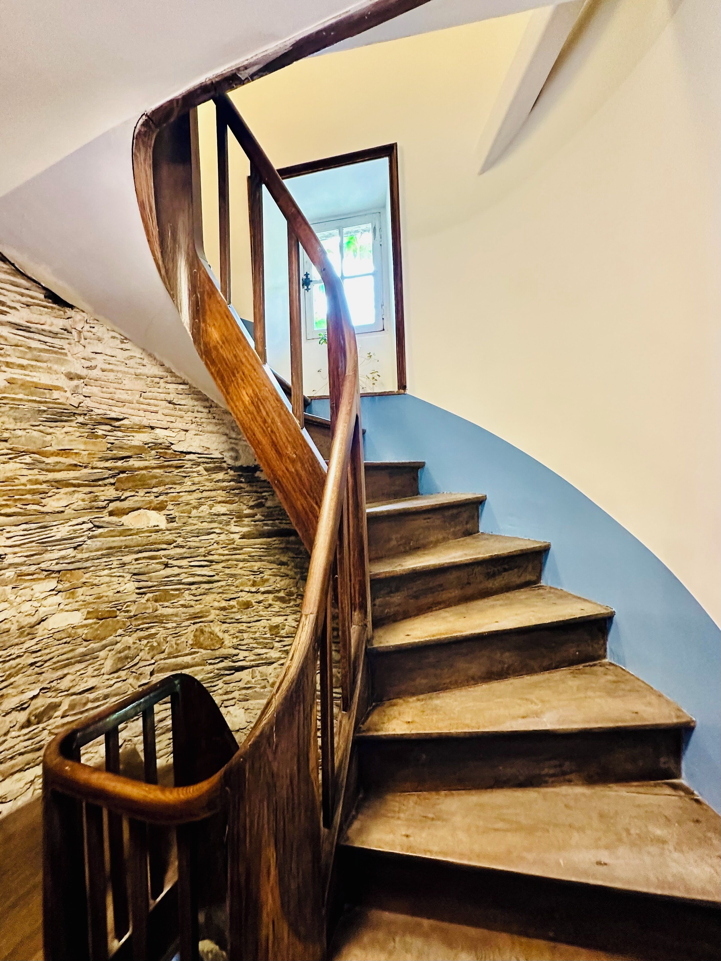 Eine Wendeltreppe mit Holzwerteln und Steinwänden.