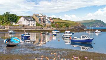 A harbor with boats, a stone wall, and buildings in the background.