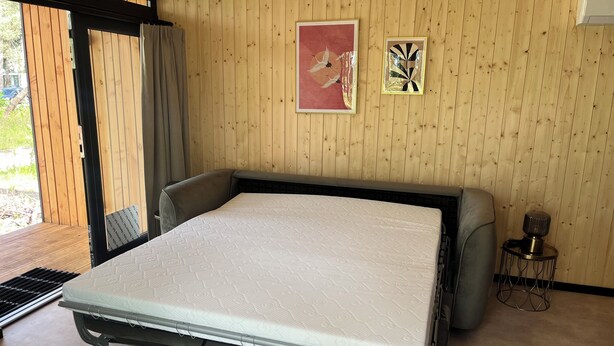 A room with a bed, wooden walls, a window, and two framed artworks. - Hella: Adventure & Nature on the Sallandse Heuvelrug (Haarle)