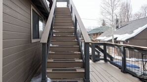 A wooden staircase with metal railings leading to a deck area. - The Loft on Humphreys:  A Charming 2 BR Apartment in Downtown Flagstaff with A/C (Flagstaff)