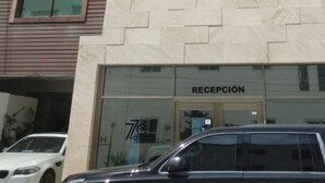 A modern building with a reception area labeled "RECEPCIÓN" and a black SUV parked in front. - 770 Apartments (Playa del Carmen)