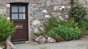 Un bâtiment en pierre avec une porte en bois portant l’inscription « Persil ».