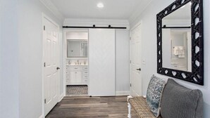 A hallway with white doors, a mirrored wall, and a bench with cushions. - Sawgrass Country Club - 26 Tifton Way - Stunning Golf Course Views! (Ponte Vedra Beach)