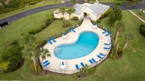 An aerial view of a resort with a large swimming pool surrounded by lounge chairs and palm trees. - Sawgrass Country Club - 26 Tifton Way - Stunning Golf Course Views! (Ponte Vedra Beach)