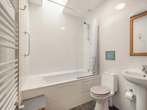 Un baño moderno con ducha, inodoro y lavamanos.