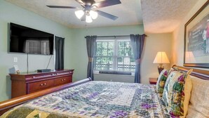 A bedroom with a bed, a ceiling fan, a window with curtains, a dresser, and a framed picture on the wall. - Creek and Mountain Views.  Can’t ask for more (Gatlinburg)