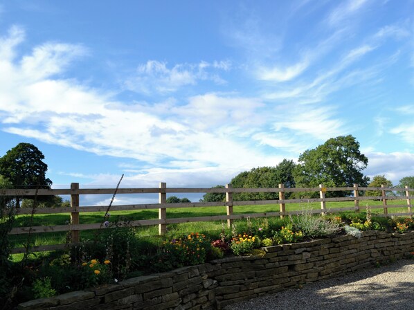 A stone wall, a wooden fence, and a grassy field with trees in the background. - 4 bedroom accommodation in Paythorne, near Skipton (Paythorne, near Skipton)
