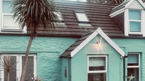 Une maison avec un toit en pente, une lucarne bien visible et une petite fenêtre décorée d’une étoile.