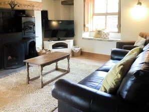 A living room with a fireplace, a television, a sofa, and a coffee table.