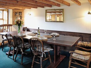 A dining area with a wooden table set for six, surrounded by wooden chairs with cushioned seats. - 2 bedroom accommodation in Gayle near Hawes (Gayle near Hawes)