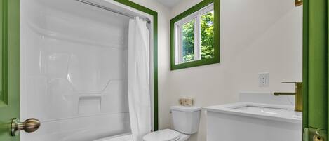 A bathroom with a bathtub, toilet, and sink.