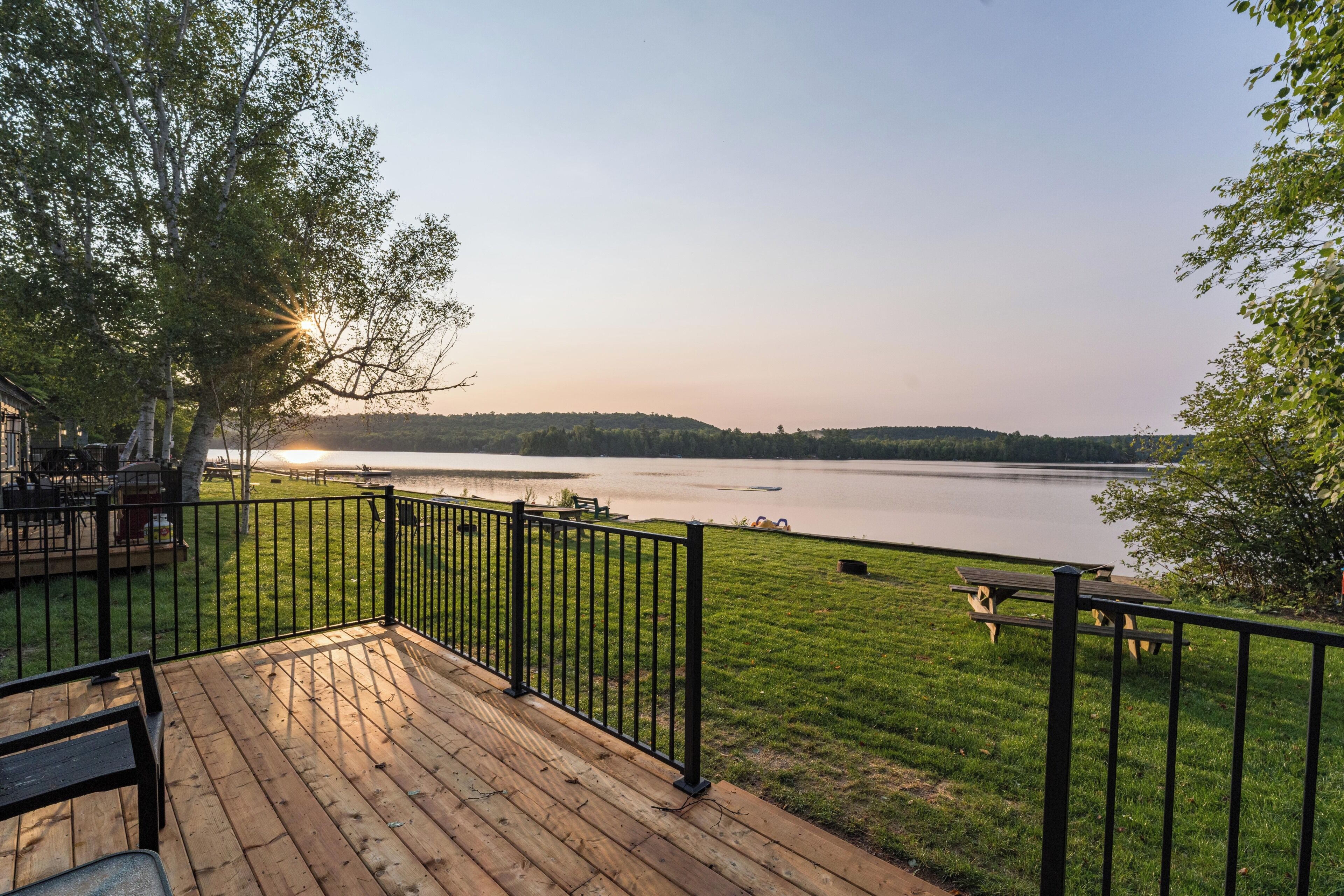 A deck with a view of a lake and distant hills.