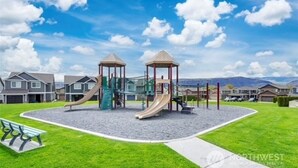 A playground with two slides and a climbing structure, surrounded by houses and a clear sky. - Watershed Condo near Large pool/hot tub. Gorge Amp shuttle nearby book separate. (Quincy)