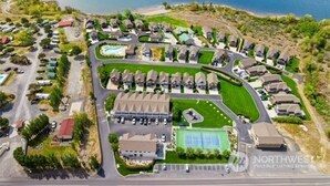 An aerial view of a residential area with houses, a swimming pool, and a road. - Watershed Condo near Large pool/hot tub. Gorge Amp shuttle nearby book separate. (Quincy)