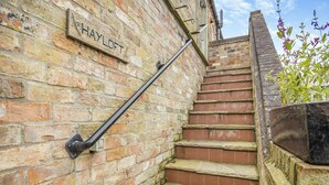 A brick staircase with a metal handrail and a sign that reads 'HAYLOFT.'