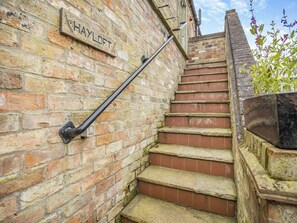 A brick staircase with a metal handrail and a sign that reads 'HAYLOFT.'