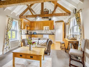 A cozy interior with a wooden table, a sofa, and a dining area.
