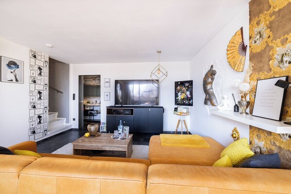 A modern living room with a sofa, coffee table, and artwork on the walls.