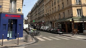 A street view with a building labeled "MILLIGRAMME" on the left, featuring a blue facade and a visible entrance.