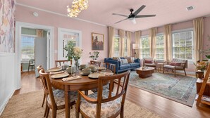 A dining area with a round table, chairs, and a ceiling fan. - Renovated 2BR w/Porch & Pool Table • San Marco (Jacksonville)