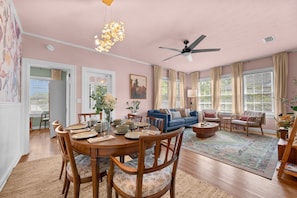 A dining area with a round table, chairs, and a ceiling fan.