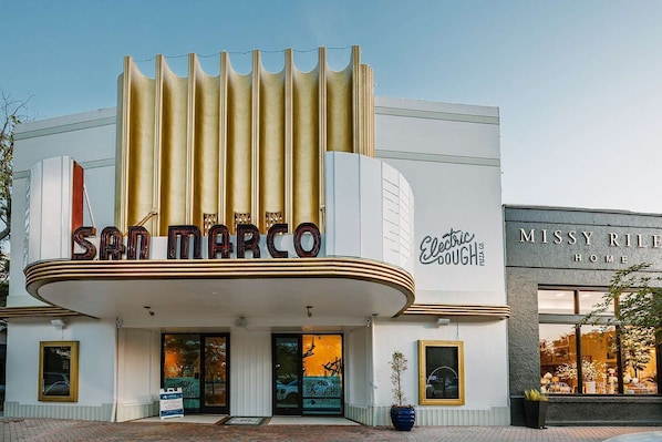 A theater with a marquee reading 'San Marco' and a sign for 'Electric Dough Pizza Co.'