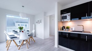 A modern kitchen with black cabinets, a stainless steel microwave, and a black countertop. - Nice apartment in Olpenitz with sauna (Olpenitz)