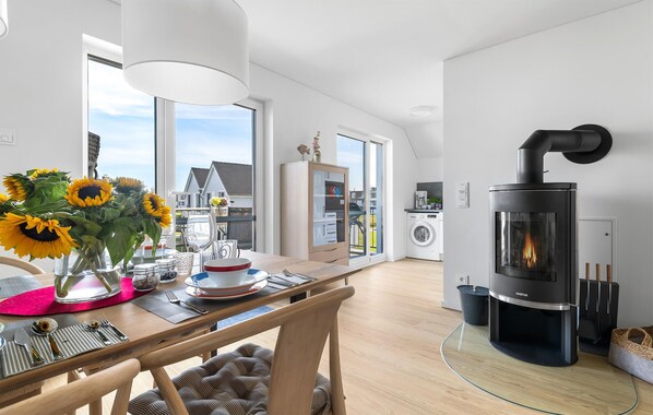 Enjoy cooking and laundry in this well-equipped kitchen with a wood-burning stove, dining area, and oven.