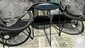 A glass door leading to a balcony with two wicker chairs and a small round table. - Gościniec Warmiński by Elite4Rent (Stawiguda)